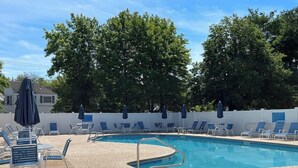 A swimming pool with lounge chairs and umbrellas, surrounded by trees. - Ocean Park Meadows. 2-bedroom, 1.5 baths condo in Old Orchard Beach. (Old Orchard Beach)