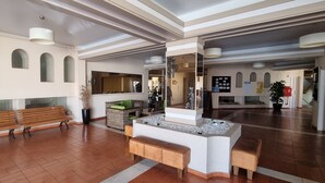 A spacious lobby with a wooden bench, a planter with dried plants, and a decorative mirror. - Comfortable apartment in a hotel residence, Chill and festive atmosphere (Albufeira)