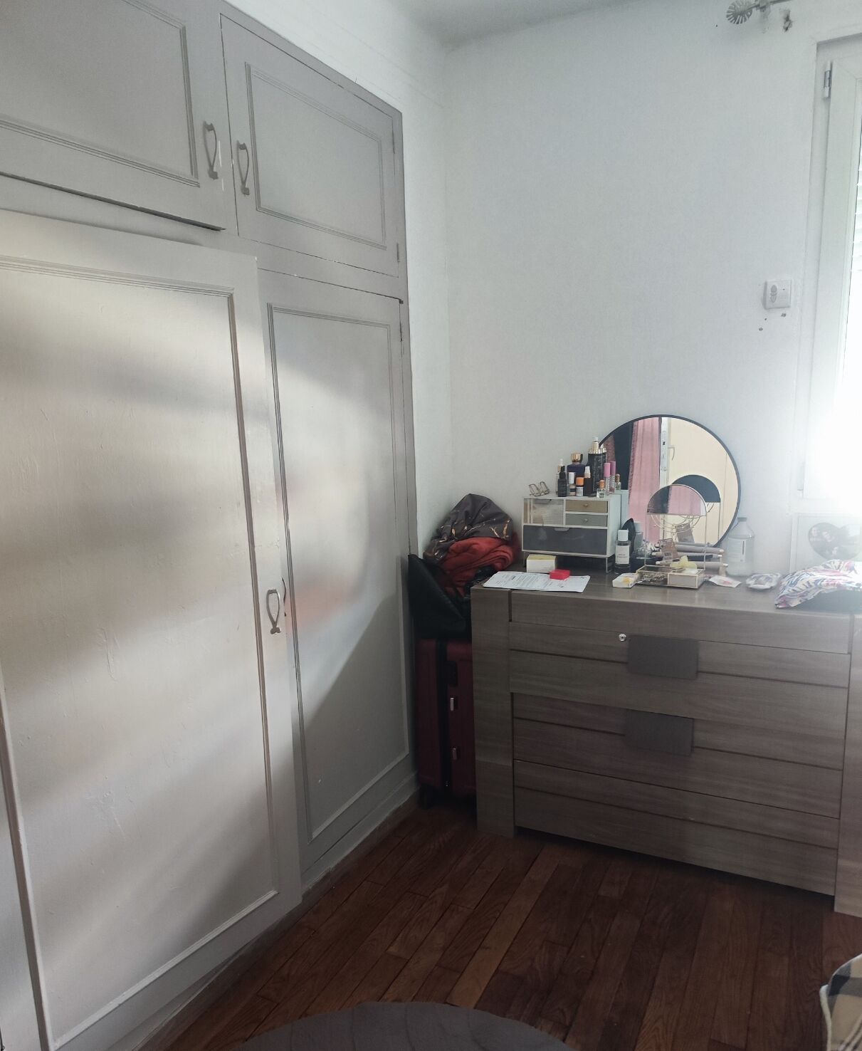 Una habitación con un aparador de madera, un espejo y un armario.