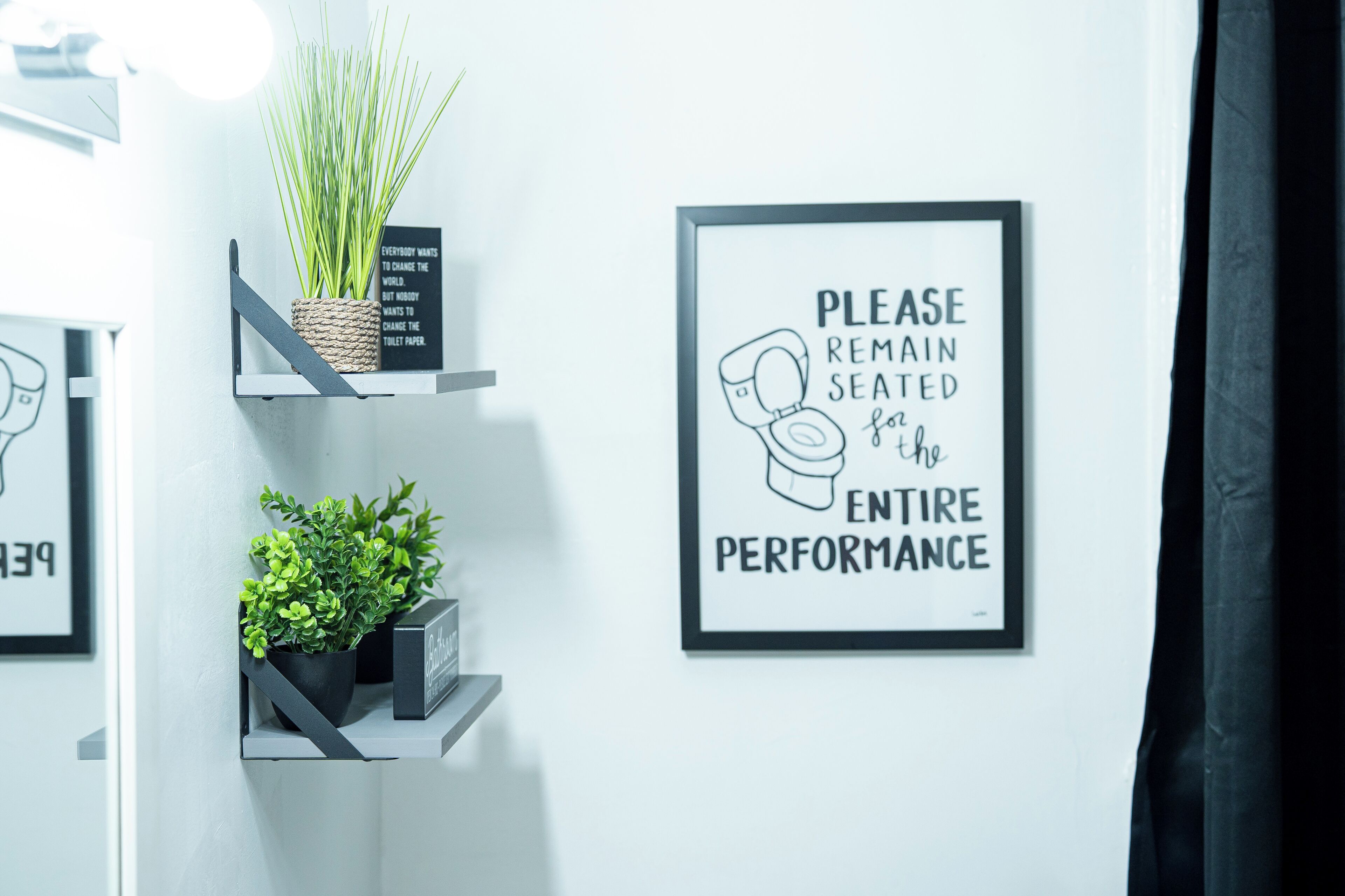 Eine Wand mit zwei gerahmten Schildern, eines mit einer Toilettenabbildung und Beschriftung, das andere ebenfalls mit einer Toilettenabbildung und Text.