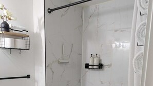 Un bagno moderno con doccia, WC e ripiano con articoli da toilette.