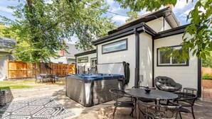 Un área de patio con un jacuzzi, mobiliario exterior y un tapiz estampado.