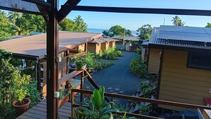 A view of a resort with multiple bungalow-style buildings, a covered walkway, and a pathway leading to the beach. - Fare atihau vairao  (Taiarapu-Ouest)