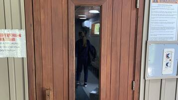 Une porte en bois avec une pancarte au-dessus indiquant « SAUNA ».