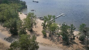 A beach with boats, a pier, and dense trees. - Cozy A-Frame Cottage, Peaceful Location, HOT TUB, Fire Pit, King Bed, Near Dells (Friendship)