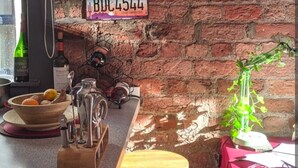 A restaurant interior with a brick wall, a bar counter, and three license plates from California, Florida, and Arizona. - Cozy 2-bedroom apartment in welcoming Liverpool with WiFi (Liverpool)
