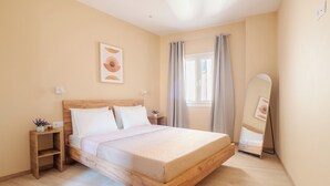 Une chambre à coucher avec un lit en bois, une table de chevet avec une lampe, une fenêtre avec des rideaux et un miroir fixé au mur.