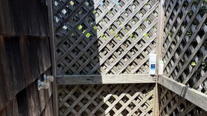 A wooden deck with a lattice fence, a metal gate, and a bottle of Ivory dish soap. - 4-bedroom house in charming Wainscott walking distance to the beach (East Hampton)