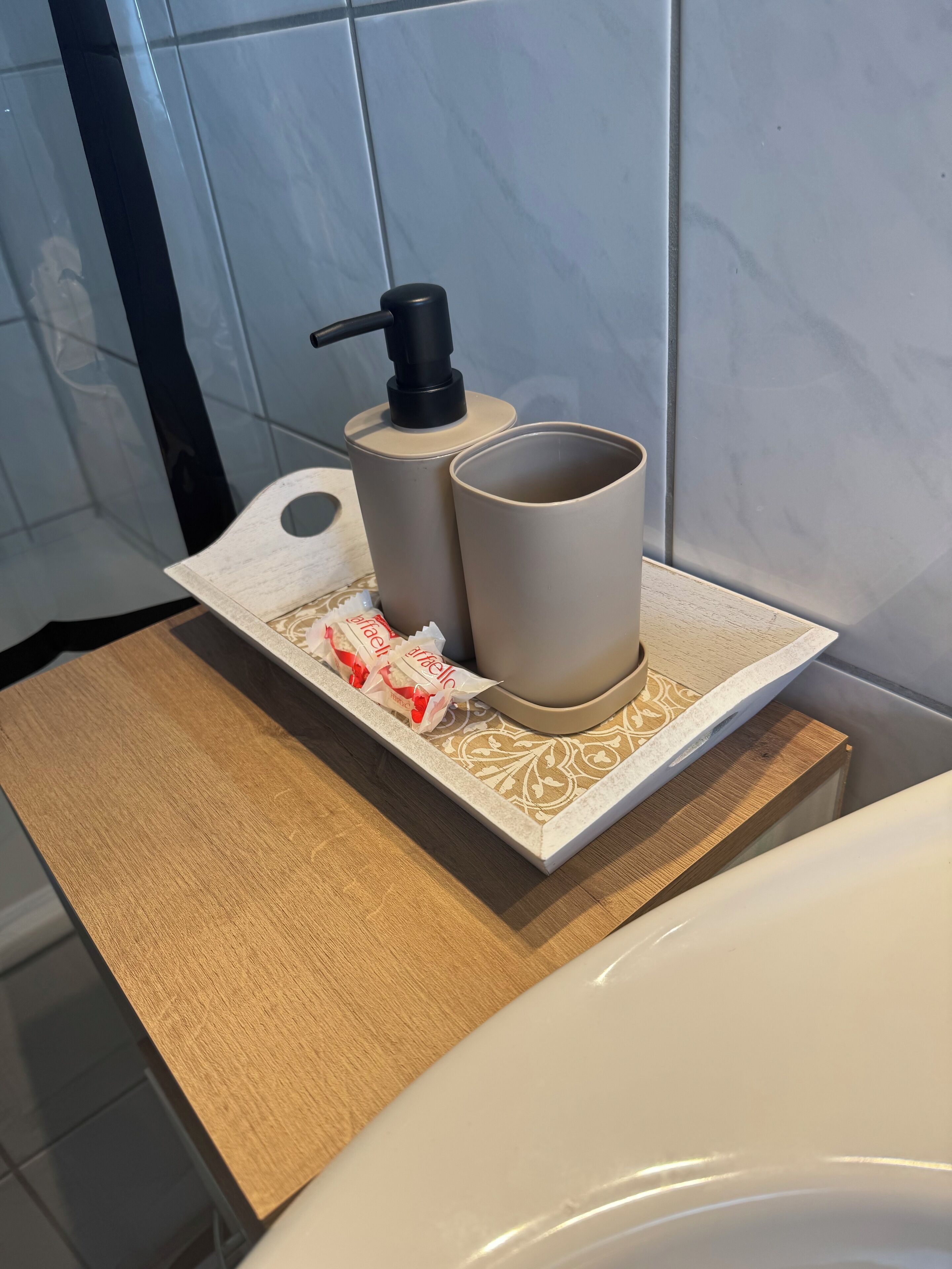 Ein Badezimmer mit einem weißen Waschbecken, einer beigen Arbeitsplatte und einer Seifenspender.