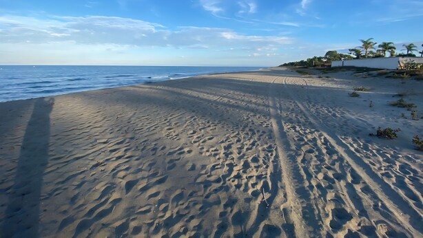 A beach with a clear sky and calm sea.