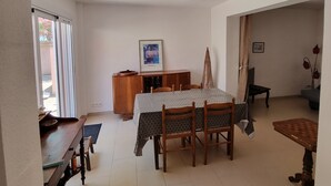 A dining area with a table, chairs, a wooden cabinet, and a framed picture on the wall.