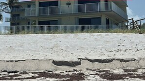 Un hotel de varios pisos con balcones, situado cerca de una playa.