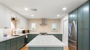 A modern kitchen with a central island, built-in appliances, and a large refrigerator. - 5 min to Old Town, Pool & Spa, 2 King Suites (Scottsdale)