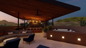 A modern outdoor lounge area with a bar, seating, and a hot tub. - Royal Grand Resorts (Quepos)