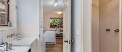 A modern bathroom with a large mirror, a white sink, and a built-in washing machine.
