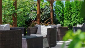 An outdoor seating area with wicker furniture and a pergola structure. - EMERALD Hotel (Ulcinj)