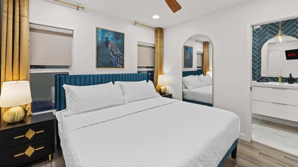 A modern hotel room with a large bed, a ceiling fan, a TV, and a minibar. - Moroccan-Inspired 1-BR Getaway near Reunion Tower (Dallas)