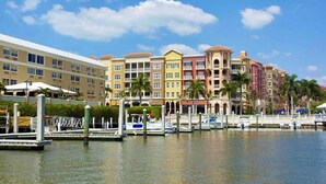 A waterfront hotel with multiple colorful buildings, docks, and boats. - Relaxing Modern 4BR Family Oasis in Napes- 10 Min to Beach & Downtown Fun (Naples)