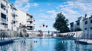 A swimming pool with a clear view of the surrounding buildings, including balconies and a tree. - Top Rated, Waterfront Condo at 19MM Amazing views! Prime location! Boat slip! (Osage Beach)