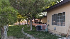 A residential property with a paved driveway, a stone pathway, and a patio area with outdoor furniture. - Cozy 1-bedroom apartment, WiFi, AC, Views! Wildlife! In charming Pahrump (Pahrump)