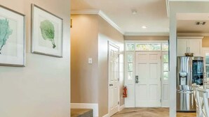 A spacious hallway with hardwood flooring, white walls, and framed artwork. - Piece of Paradise located at Hawks Cay in Duck Key (Duck Key)
