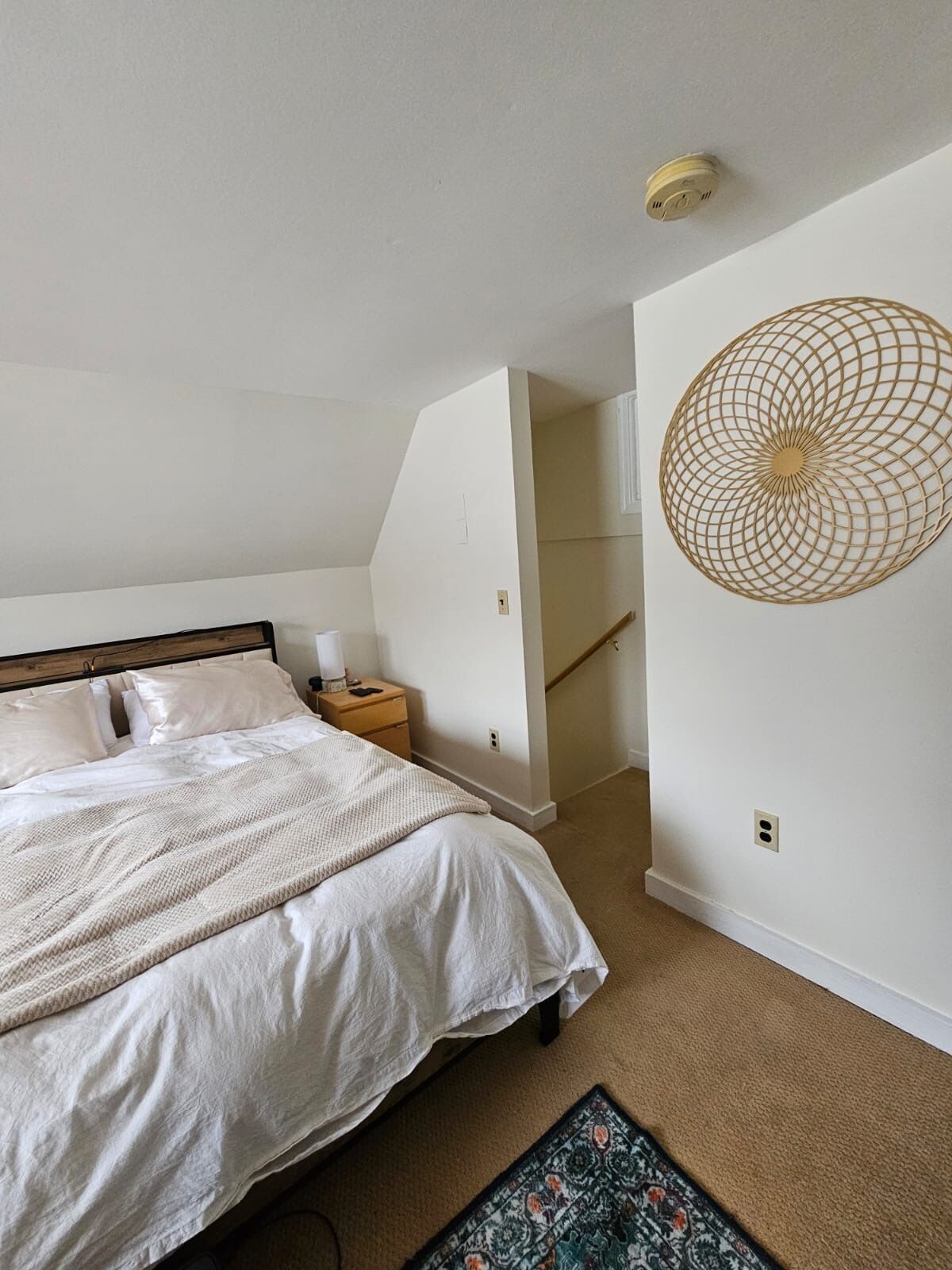 Ein Schlafzimmer mit einem Bett, einem Nachttisch und einer Wanddekoration.