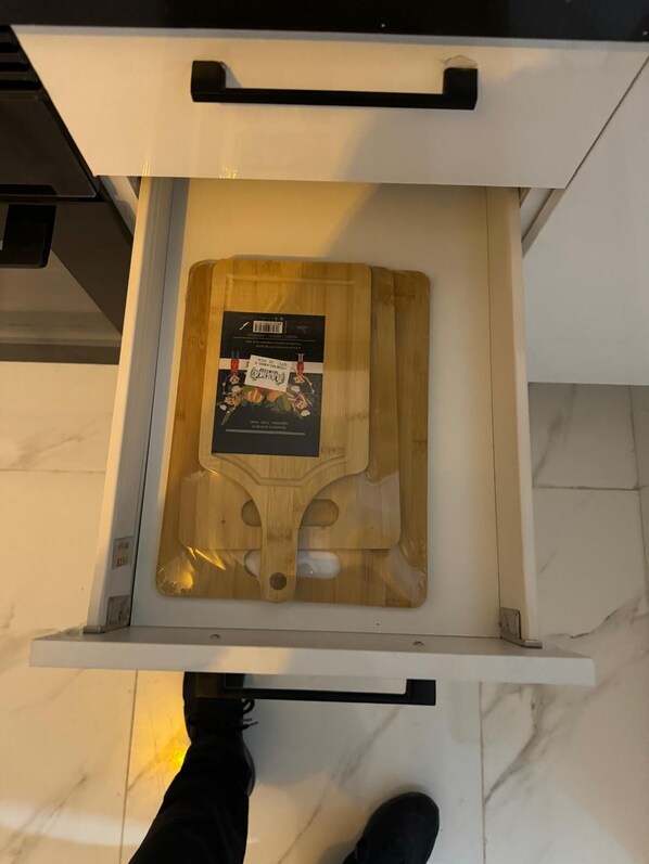 Un cajón con una tabla de cortar de madera y un paquete de alimentos.