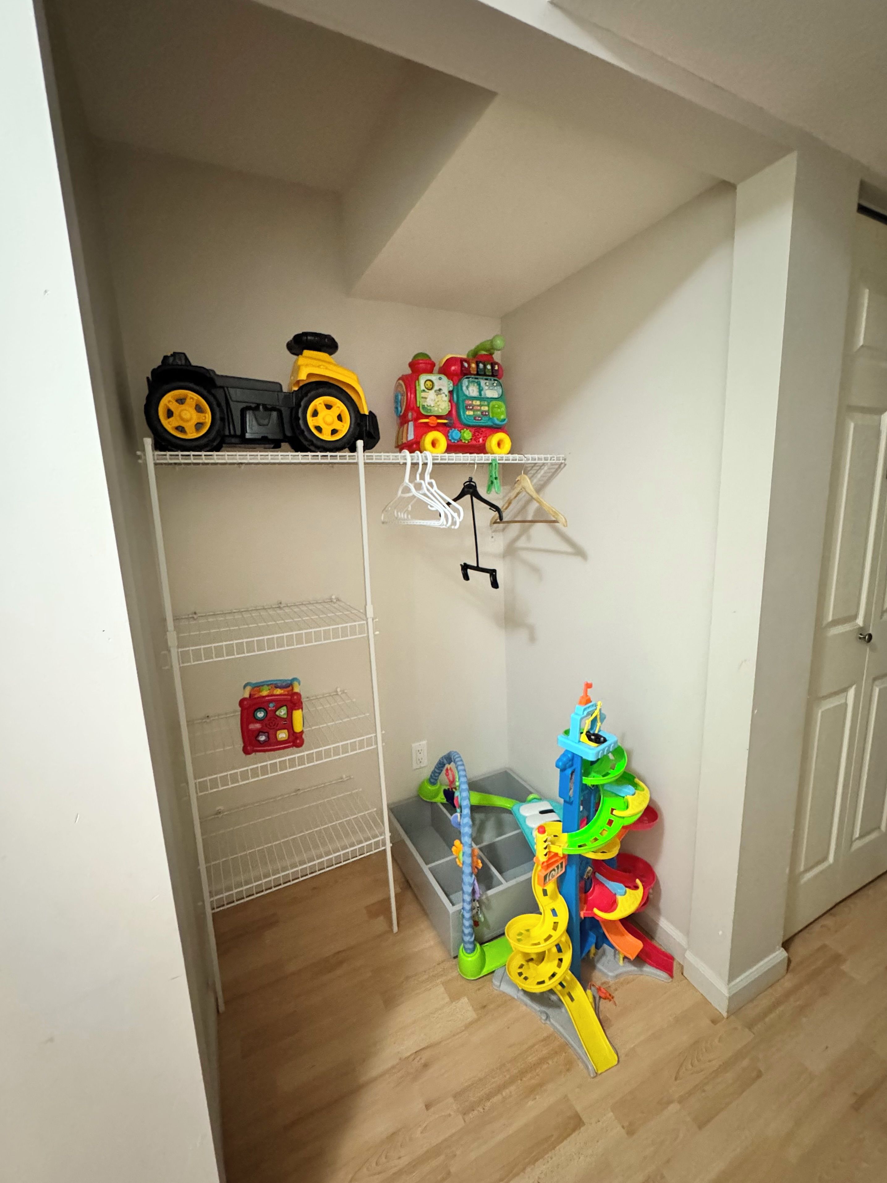 Ein Zimmer mit einer weißen Tür, einer weißen Wand und einem Holzboden.