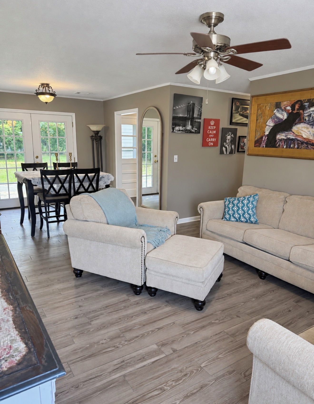 A living room with a sofa, ottoman, and a dining table with chairs.