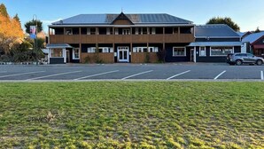 A two-story building with a flat roof, large windows, and a sign reading "TURDO A LODGE". - The Turoa Lodge Ohakune (Ohakune)