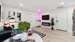 Ein modernes Wohnzimmer mit einem grünen Sofa, einem Marmortisch und einem Kamin.