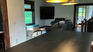 A modern kitchen with a long countertop and pendant lighting. - A Peaceful Driftless Farm Stay Awaits Near A Trout Stream (Muscoda)