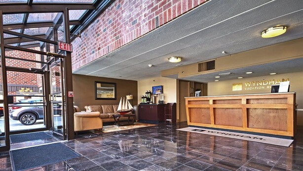 A hotel lobby with a reception desk, a sofa, and a coffee table. - Week long hotel suite unit at Wyndham Inn on the Harbor in Newport (Newport)