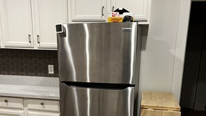 A stainless steel refrigerator in a kitchen with white cabinets and a wooden stool. - Charming, private 3BR cottage with WiFi, A/C, full washer & dryer in Oakland (Oakland)