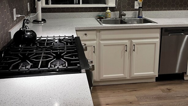A modern kitchen with white cabinetry, a stainless steel dishwasher, and a gas stove. - Charming, private 3BR cottage with WiFi, A/C, full washer & dryer in Oakland (Oakland)