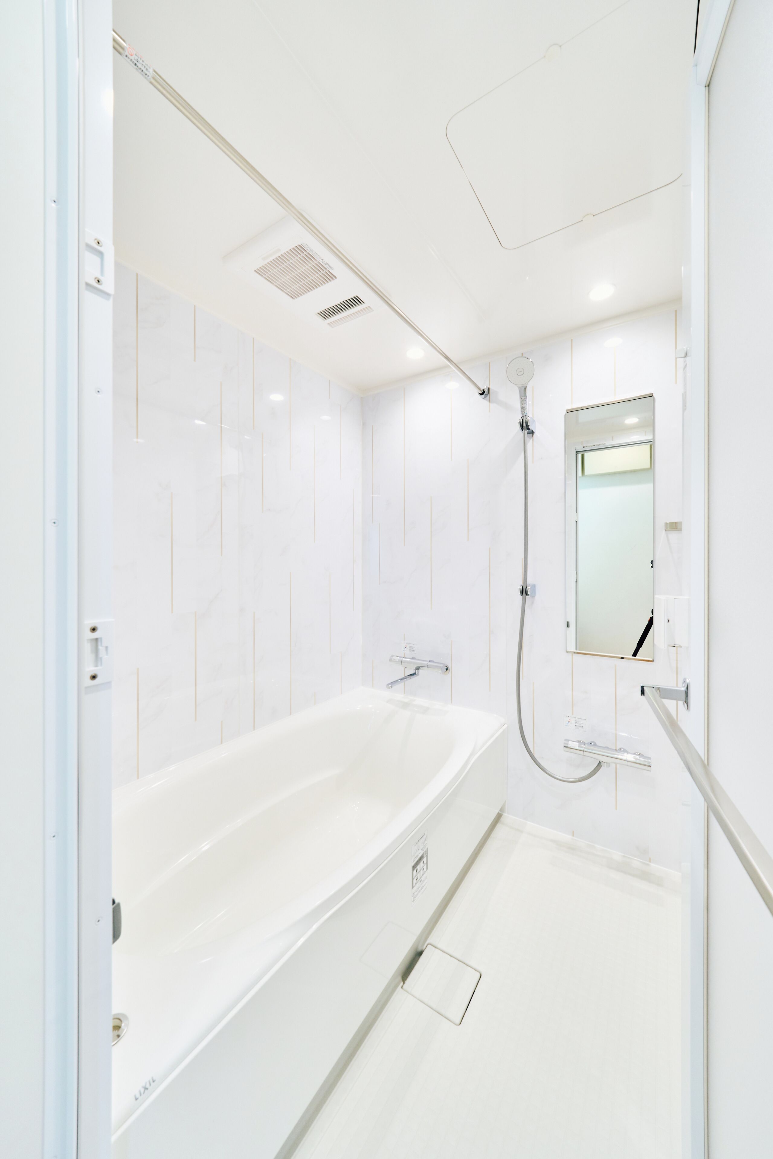 A modern bathroom with a large bathtub, a shower, and a mirror.