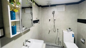 Een badkamer met twee wastafels, een spiegel en een douche.