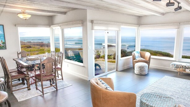 Una habitación amplia con un gran ventanal corredero que da a un balcón con vistas al océano.
