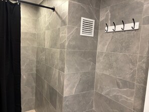 Regadera, secadora de cabello, toallas, papel de baño 