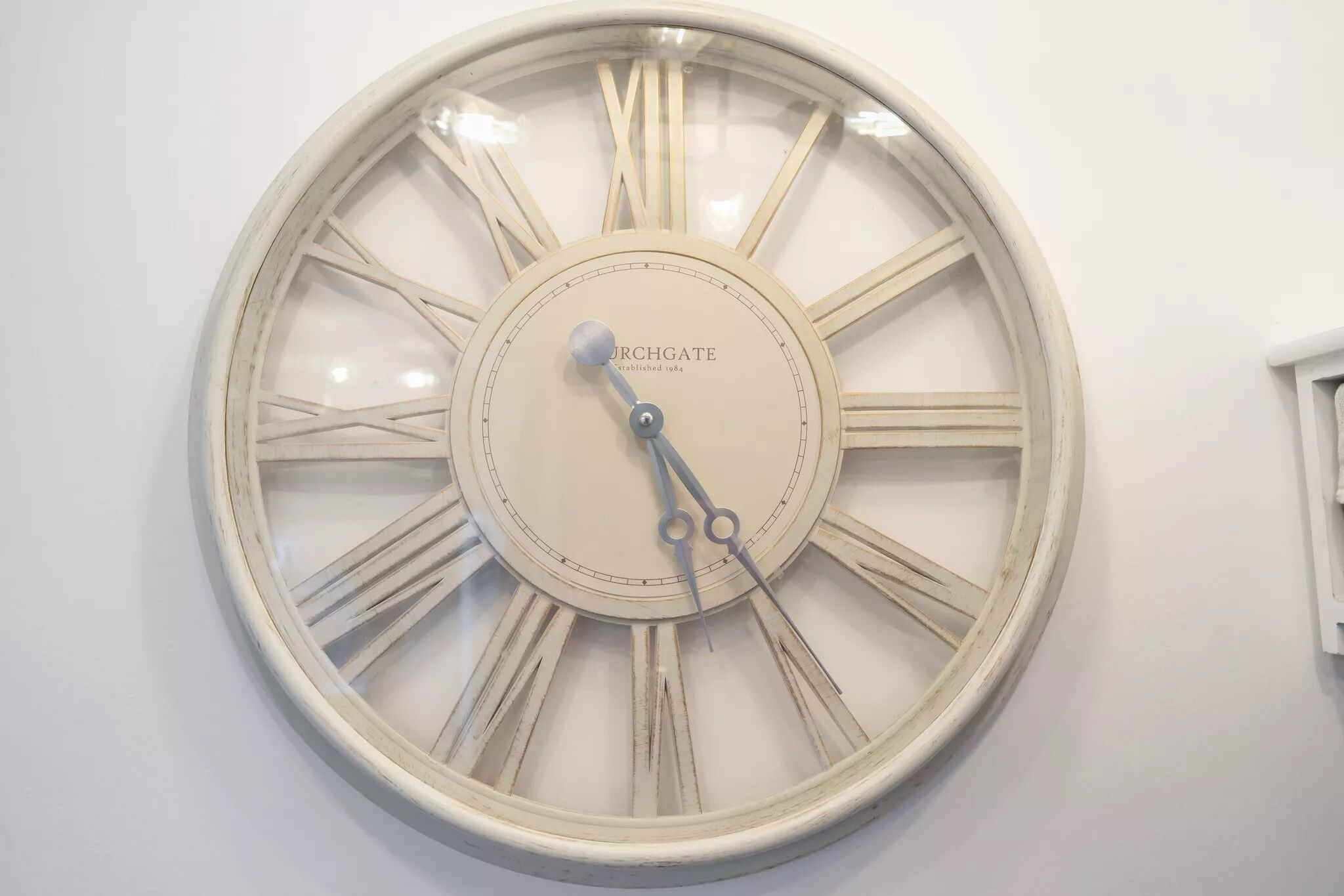 Eine Wanduhr mit römischen Ziffern und dem Markennamen "ORCHGATE".