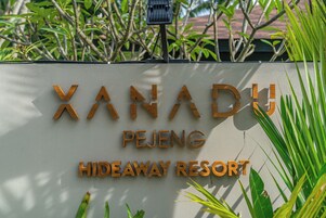 Letrero de madera que indica el nombre y la ubicación de Xanadu Pejeng Hideaway Resort.