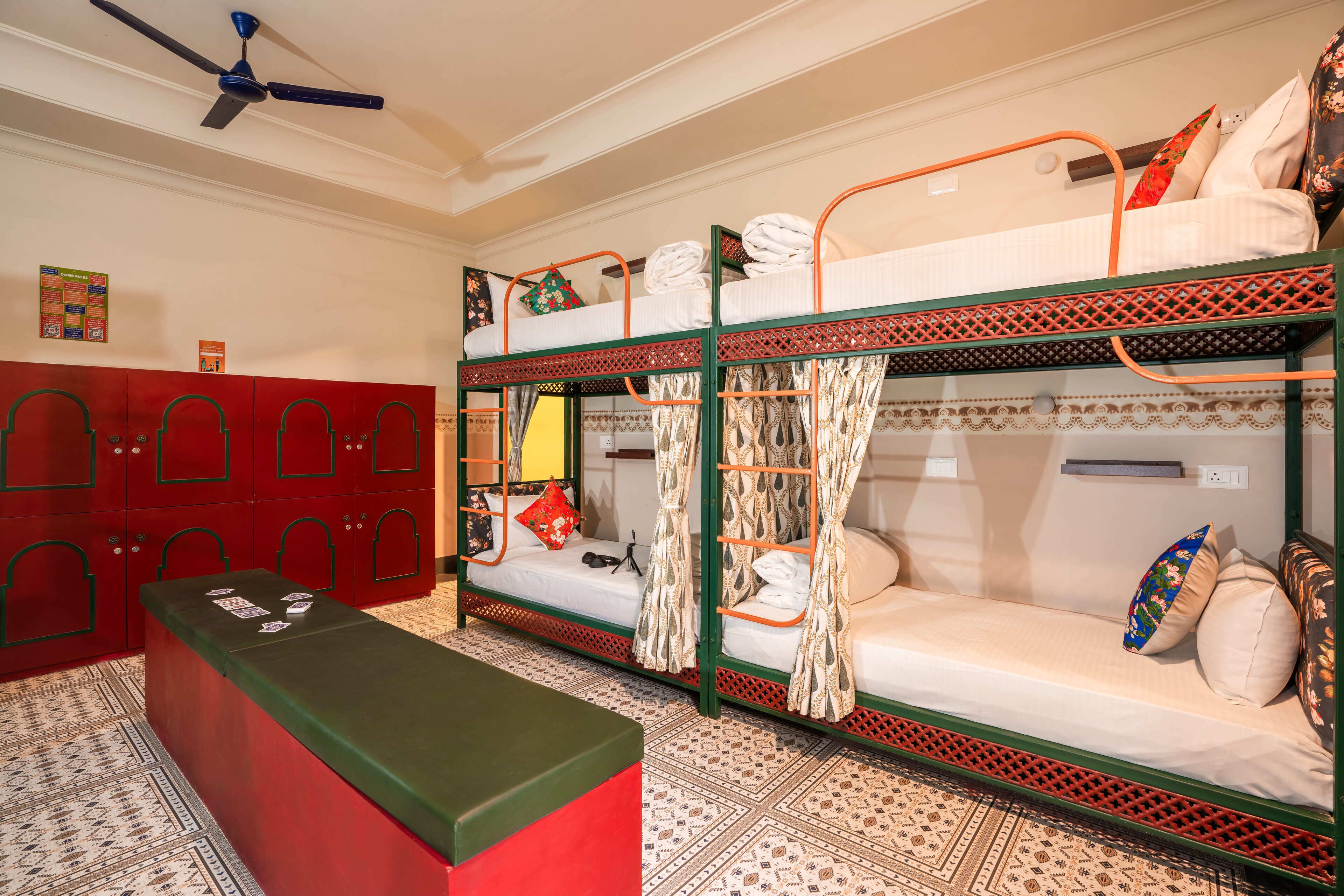 Una habitación con literas, un armario rojo y un piso estampado.