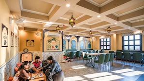 Un ristorante con soffitto alto, pavimento a motivi e arredamento tradizionale.