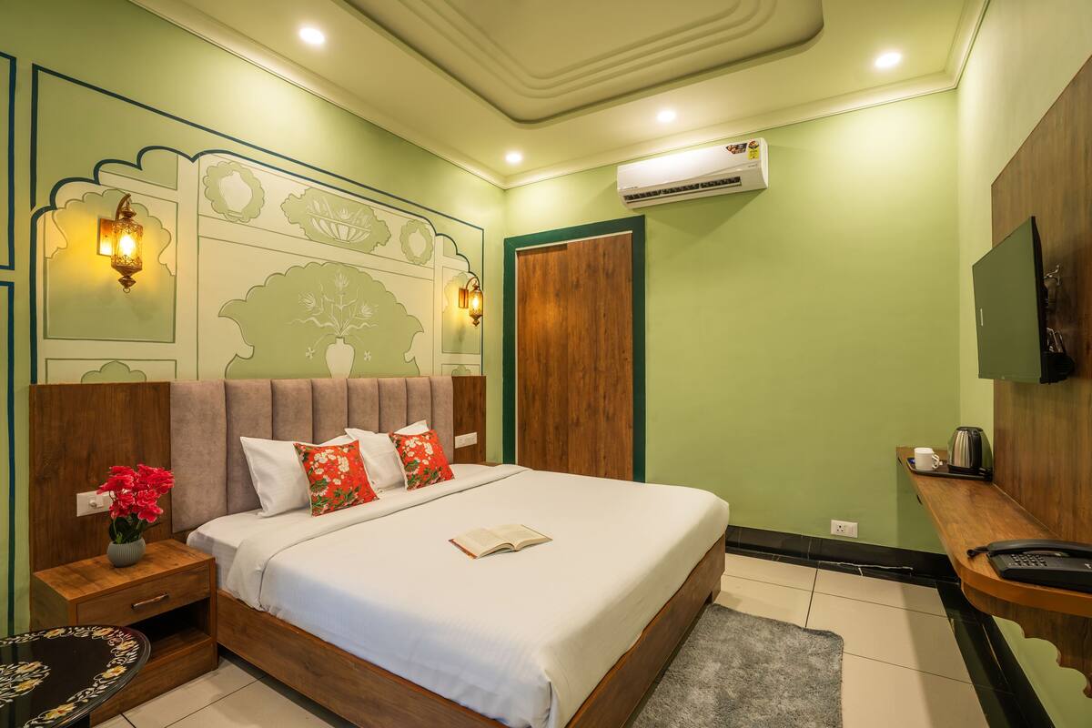 A neatly arranged bedroom with a bed, bedside table, and a small table with a vase of flowers.