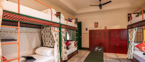A room with bunk beds, a desk, and a wardrobe.