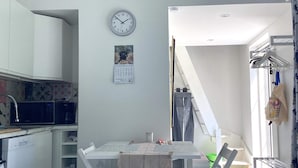 A compact kitchen with a microwave, a clock, and a calendar on the wall. - 3 Person Holiday Home in Grimeton (Grimeton)