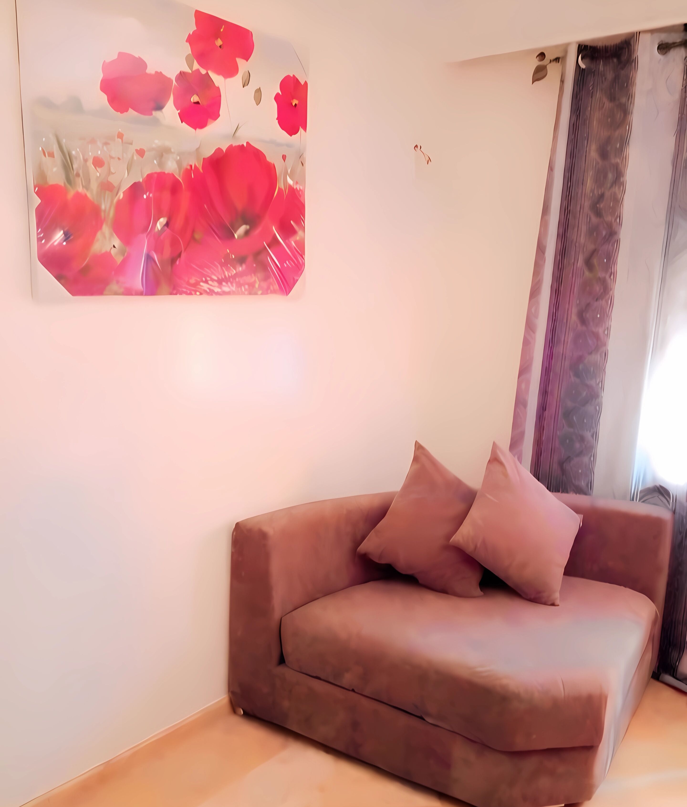 Una sala de estar con un sofá marrón y una gran obra de arte floral en la pared.