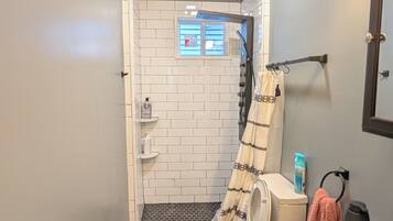 Een douche, handdoeken, zeep, toiletpapier