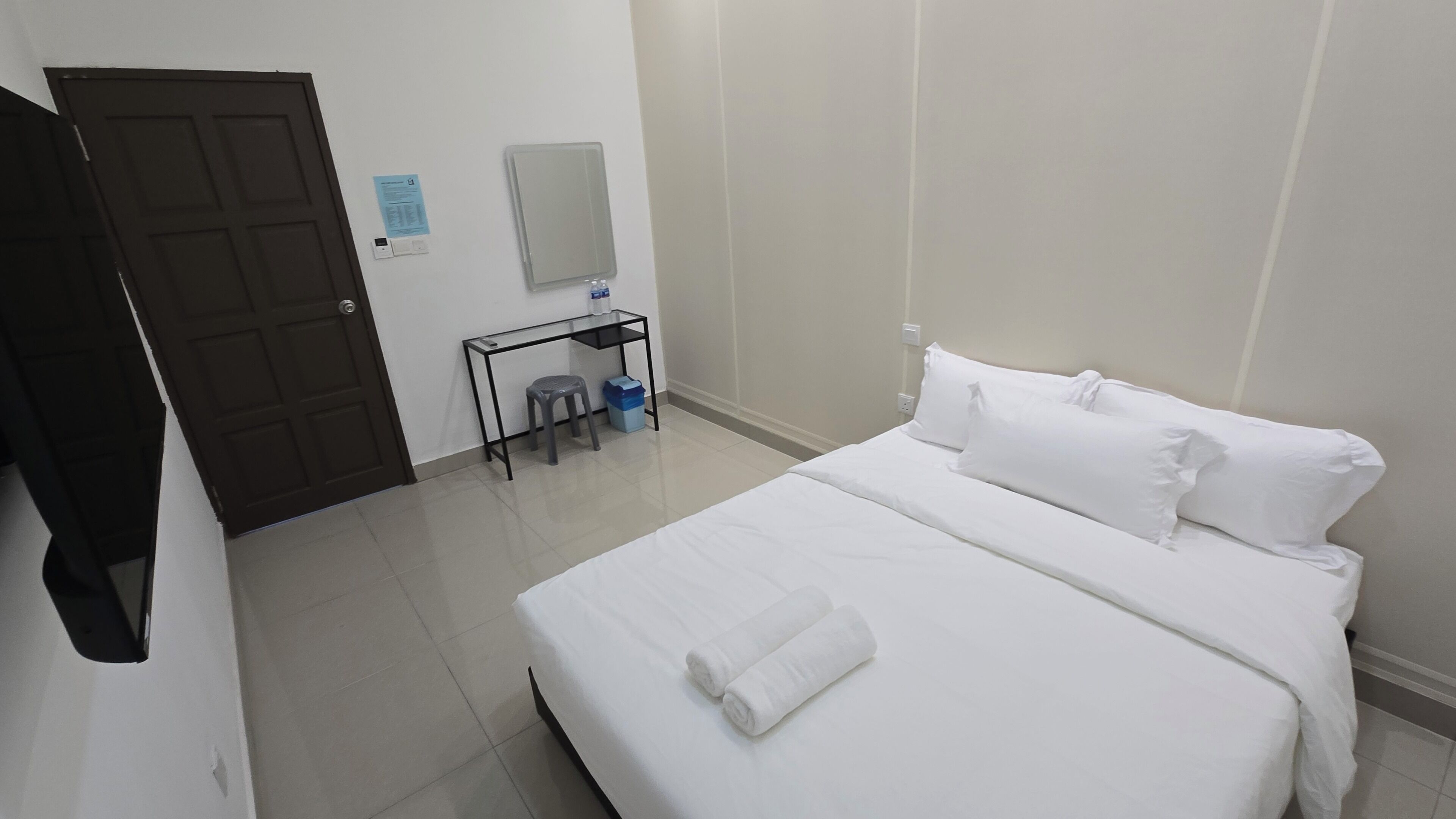 A hotel room with a bed, a desk, and a chair.
