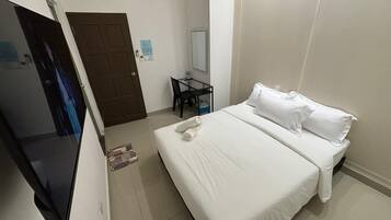 Een hotelkamer met een bed, een bureau, een stoel en een televisie.